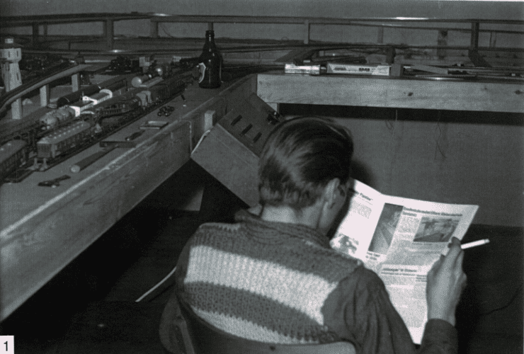 Schwarzweißfoto: Ein Clubmitglied sitzt mit einer Zeitschrift vor der im Bau befindlichen Anlage
